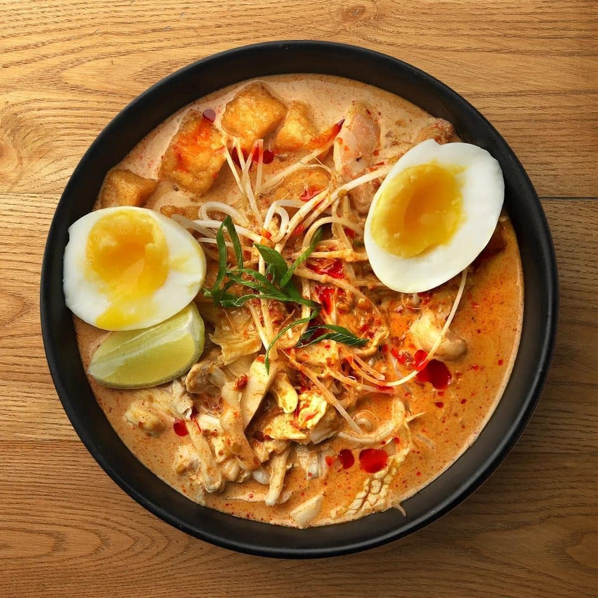 Creamy laksa noodle bowl with soft-boiled egg, tofu and bean sprouts